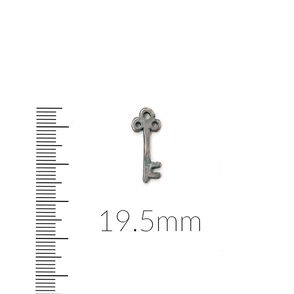 alt="artisan verdigris skeleton key charm"